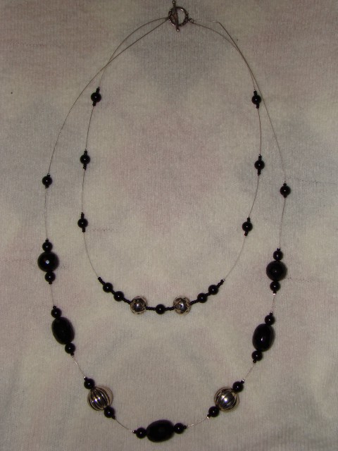 Dvoslojna dolga verižica iz perl kovinskega videza in steklenih črnih perl