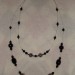 dvoslojna dolga verižica iz perl kovinskega videza in steklenih črnih perl