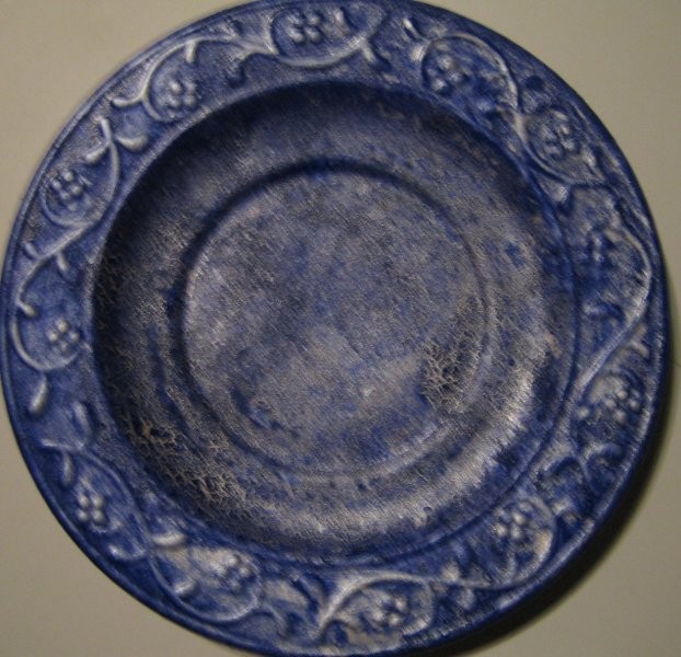 Krožnik iz keramike,spodaj pobarvan s srebrno barvo,zgoraj z modro in obrisano s krpo... e