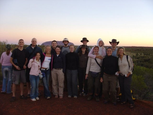 Po zavzetem cakanju na soncni zahod se ena skupinska in v ozadju slavna skala Uluru