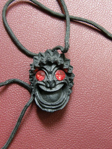 Obesek maska, dolžina 3,5cm, trd črn les, namesto oči rdeča 