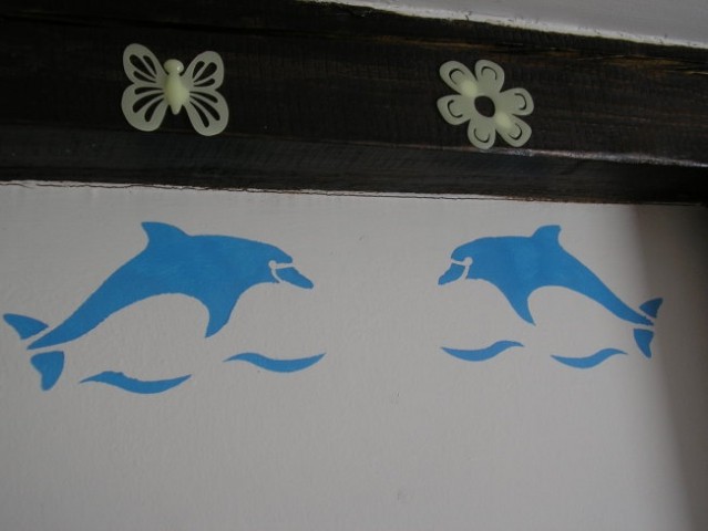 Stene v hčerini sobi so okrašene z delfinčki, šablona