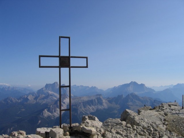 Križ na vrhu Tofane di Mezzo; visoki gori v ozadju sta Pelmo (3168 m; tik levo ob križu) t