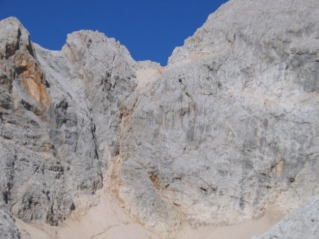 Stena pod Triglavsko škrbino, preko katere pelje pot (le-ta poteka desno od grape, ki pada